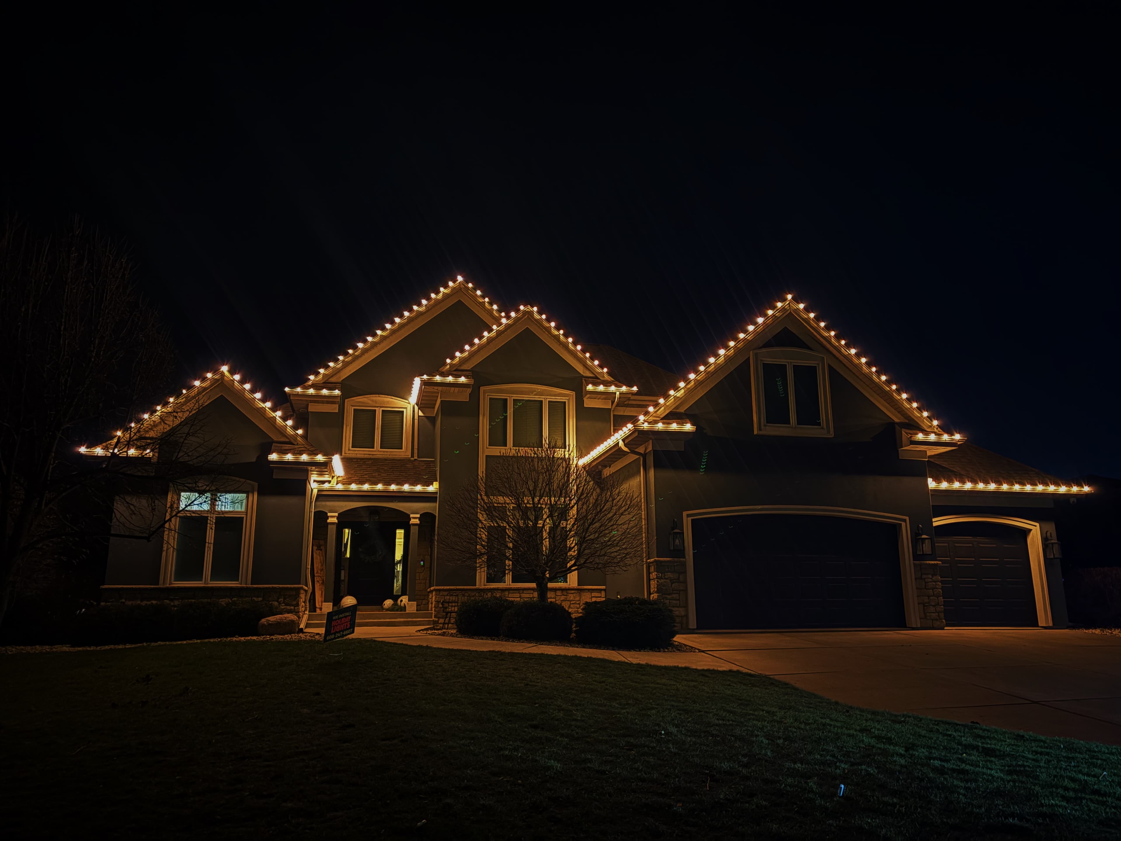Kussmaul Co. holiday lighting on full gable two-story home at night