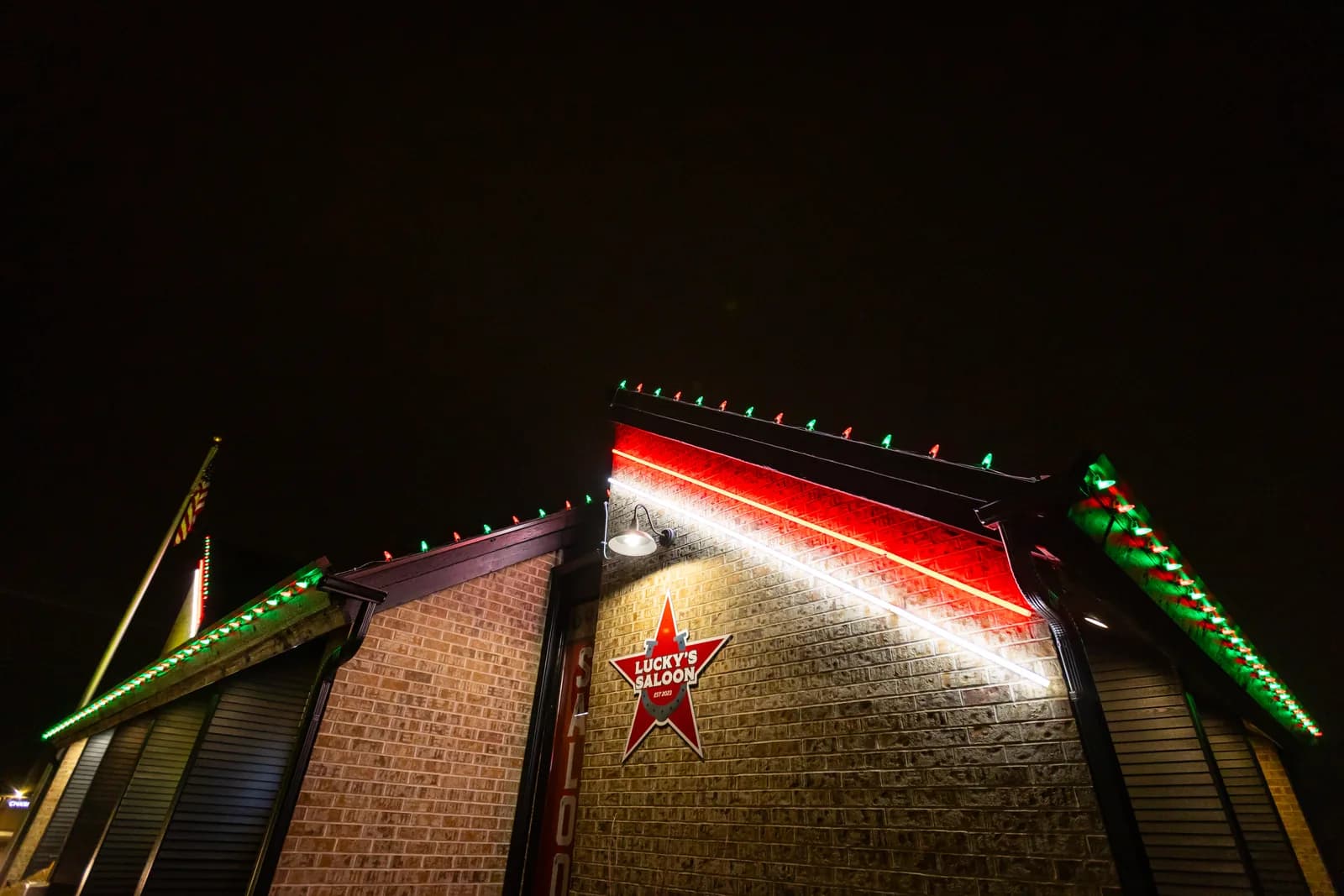 Real Kussmaul Co. holiday lighting installation on a commercial building's gable, red rope light with green and red bulbs