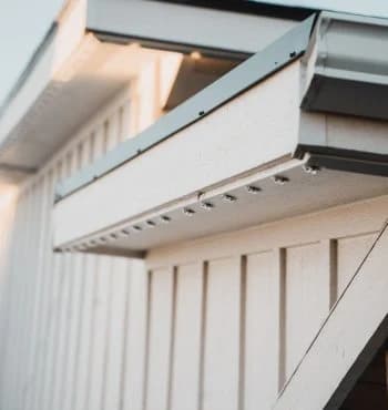Real Kussmaul Co. permanent lighting fixtures mounted along a soffit, barely visible by day