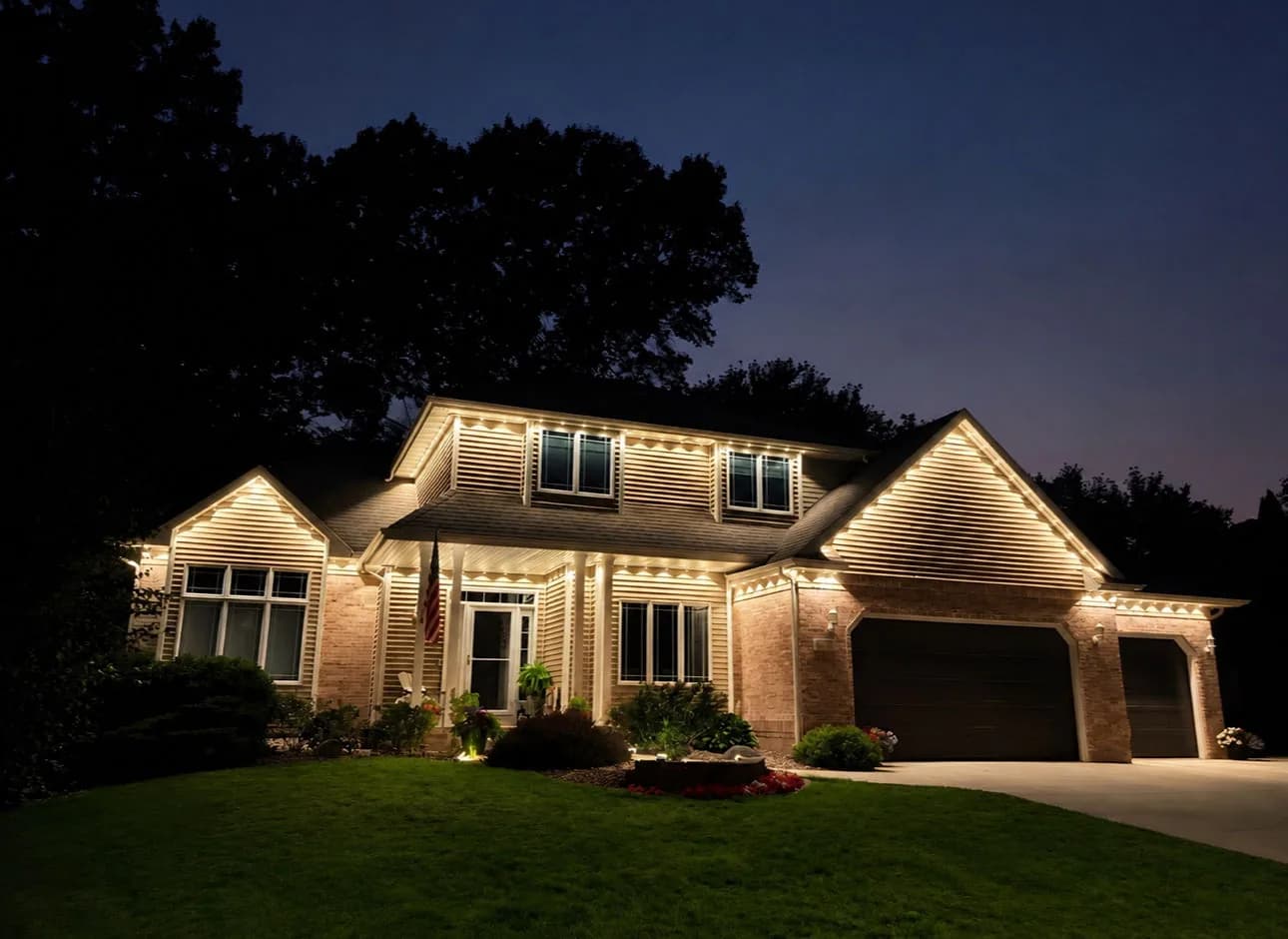 Real Kussmaul Co. permanent lighting outlining a large two-story estate in warm white at night