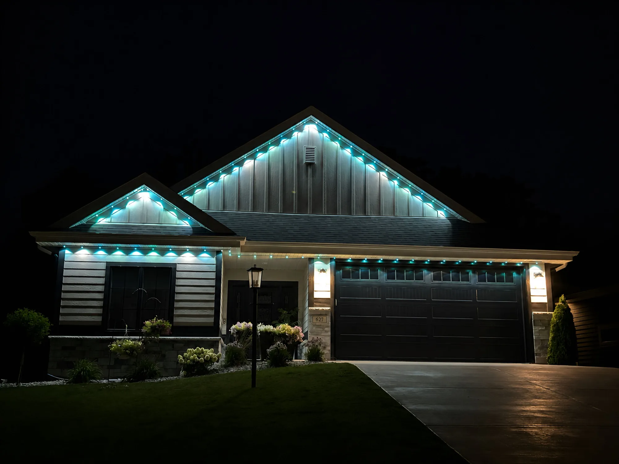 Real Kussmaul Co. permanent lighting running a teal scene across a full home and driveway at night