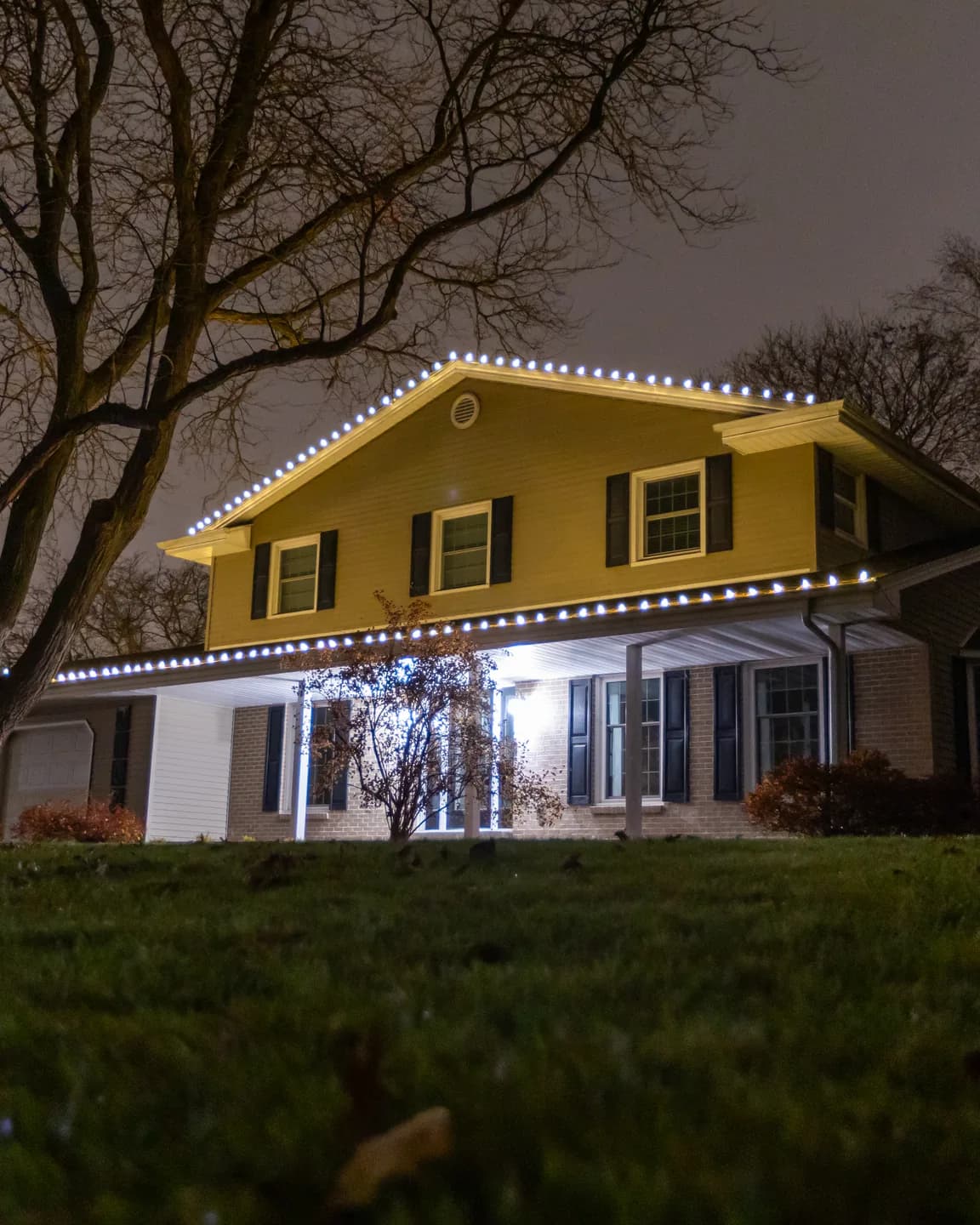Real Kussmaul Co. holiday lighting installation with cool-white lights along a two-story home's roofline