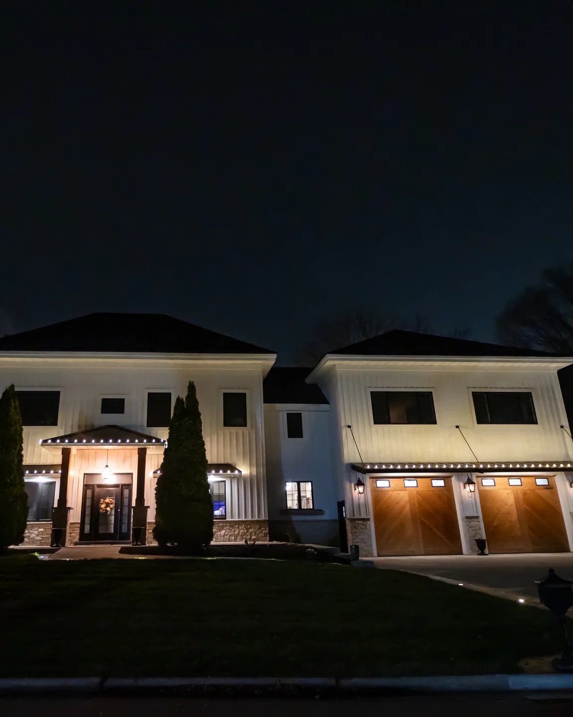 Real Kussmaul Co. holiday lighting installation with warm accent lighting across a home's front at night