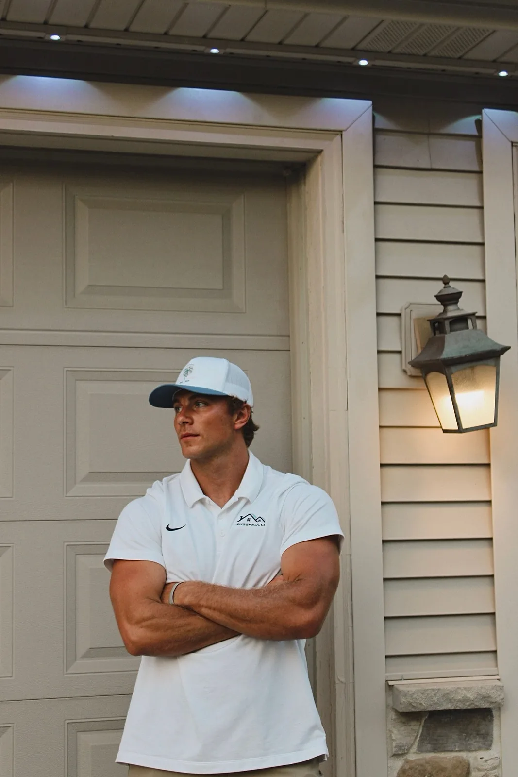 Tressin Kussmaul, owner of Kussmaul Co., in front of a home lit by a Kussmaul permanent lighting install
